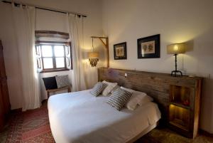 Un dormitorio con una gran cama blanca y una ventana en Herdade da Negrita, en Santo Aleixo