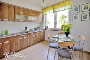 a kitchen with a table and chairs and a sink at Willa Ultima in Łeba