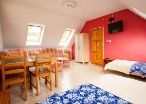 a room with a dining table and a red wall at Halinówka - Twoje Miejsce w Górach Sowich in Pieszyce