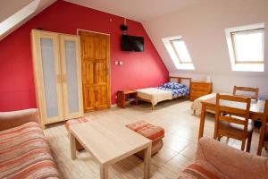 a living room with a couch and a bed and a table at Halinówka - Twoje Miejsce w Górach Sowich in Pieszyce