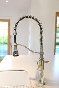 a kitchen sink with a metal faucet at Modern Comfy Retreat Patio Outdoor Salt Hot Tub in East Hampton