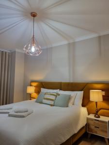 - une chambre avec un grand lit blanc et une lumière dans l'établissement Diamante house com garagem privada, à Braga