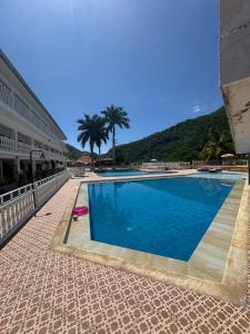 a swimming pool next to a building with palm trees at Montaña de Anapoima in Apulo