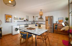 a kitchen with a table and chairs and a refrigerator at Stunning Apartment In Ponte Leccia in Ponte-Leccia