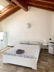 - une chambre blanche avec un lit et un réfrigérateur dans l'établissement Casa Cleopatra I, à Bergame