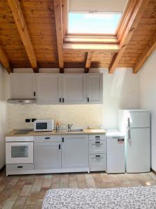 une cuisine avec des appareils blancs et un plafond en bois dans l'établissement Casa Cleopatra I, à Bergame