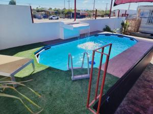 a swimming pool with a slide in the grass at Casa Konsag in San Felipe