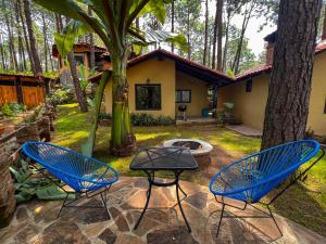 dos sillas azules y una mesa en un patio en Cabañas Las Morenas Mazamitla, en Mazamitla