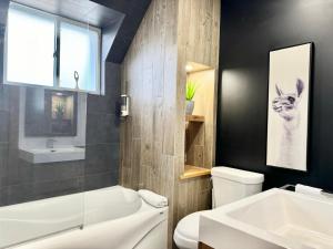 a bathroom with a white tub and a toilet and a sink at Wolfe Chutes-Montmorency in Boischâtel
