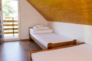 2 camas en una habitación pequeña con ventana en Domki Jasna Polana en Jastrzębia Góra