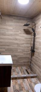 a bathroom with a shower with a wooden wall at mood villa kazbegi in Stepantsminda +4 photos