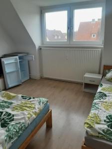 a bedroom with two beds and two windows at Bebra, Aparthotel, Im Göttinger Bogen 35 in Bebra