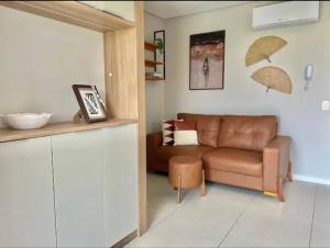 ein Wohnzimmer mit einem Sofa und Sonnenschirmen an der Wand in der Unterkunft Canto dos pássaros in Governador Celso Ramos