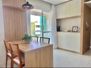 eine Küche mit einem Holztisch mit Stühlen und einem Esszimmer in der Unterkunft Canto dos pássaros in Governador Celso Ramos