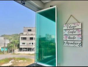 ein Spiegel in einem Fenster mit einem Schild darauf in der Unterkunft Canto dos pássaros in Governador Celso Ramos + 19 Fotos