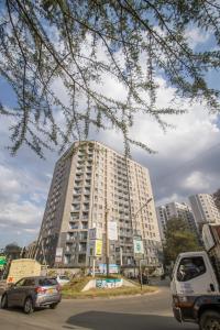 内罗毕Flat in Lavington的一座高楼，前面停着汽车