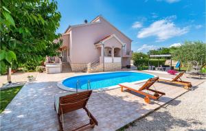 basen z dwoma krzesłami i dom w obiekcie Three-Bedroom Holiday Home In Murvica w mieście Murvica