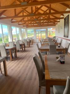 a dining room with tables and chairs and windows at Papa Bear Bjelasnica in Trnovo