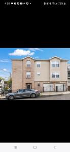 a car parked in front of a brick building at NYC & Downtown Newark Commuter Dream Stay in Newark