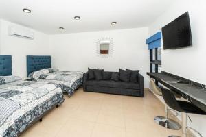 a living room with two beds and a couch at Apartamentos Torre II Condominios - Pet Friendly in Mazatlán