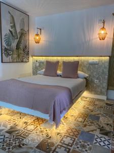 a bedroom with a large bed with purple sheets at Hacienda de las Indias, Camagüey in Granadilla de Abona