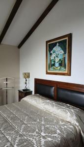 a bedroom with a bed and a painting on the wall at Casa Golmar 20 in Cedeira