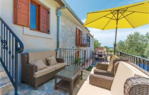 a patio with chairs and an umbrella on a balcony at Two-Bedroom Holiday Home In Jagodnja Gornja in Gornja Jagodnja