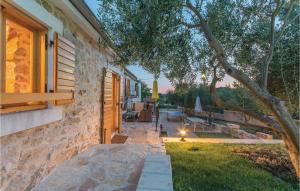 a stone house with a pathway leading to a yard at Two-Bedroom Holiday Home In Jagodnja Gornja in Gornja Jagodnja