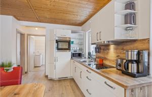 a kitchen with white appliances and a wooden ceiling at Ferienwohnung Altefähr in Altefähr