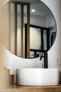 a bathroom with a round mirror on a sink at Céleste Beauté & Spa in Nalinnes