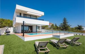 una casa con piscina y 2 sillas de césped en Villa Calvi, en Zadar