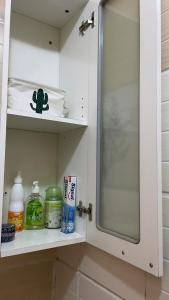 a bathroom shelf with a sink and a mirror at Garden Room in Nzamata