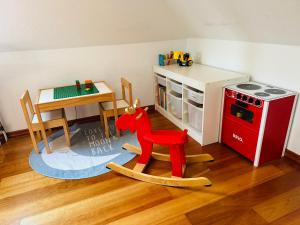 a toy room with a table and a red rocking horse at Apartments Braunschweig - Charlys Home - Küche - Fachwerk - Familie in Braunschweig