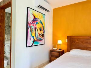 une chambre avec une peinture d'un poisson sur le mur dans l'établissement studio au coeur de la marina, à Puerto Aventuras 27 autres photos