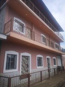 ein rosafarbenes Gebäude mit Fenstern und einem Balkon in der Unterkunft Quinta Altagracia in La Unión