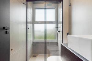 a bathroom with a shower and a toilet and a window at Res. Tribeca 350m Rua Coberta by Achei Gramado in Gramado +27 photos