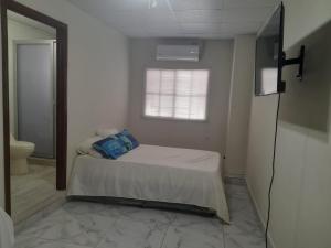 ein Schlafzimmer mit einem Bett in einem Zimmer mit einem Fenster in der Unterkunft Quinta Altagracia in La Unión