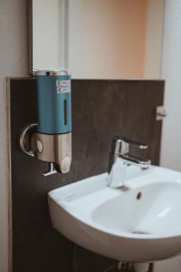 a sink in a bathroom with a blue water mixer at Große Freiheit in Ellzee +71 photos