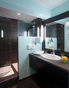 a bathroom with a sink and a mirror at Logis Hôtel Clair Matin in Le Chambon-sur-Lignon