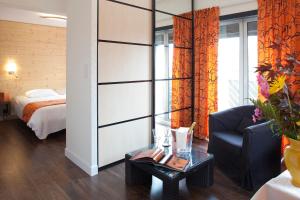 ル・シャンボン・シュル・リニョンにあるLogis Hôtel Clair Matinのベッド、ソファ、テーブルが備わる客室です。