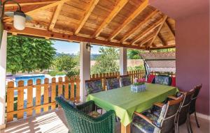 a patio with a green table and chairs on a deck at Holiday Home Prolozac Donji 12 in Donji Proložac