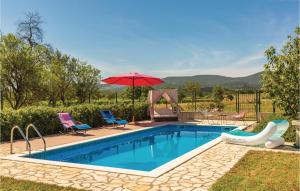 a pool with a red umbrella and chairs and a table and an umbrella at Holiday Home Prolozac Donji 12 in Donji Proložac