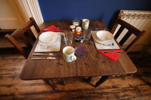 a wooden table with plates and utensils on it at Laston House in Ilfracombe