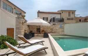 una piscina con due sedie e un ombrellone di Holiday Home Kavran Ii a Kavran