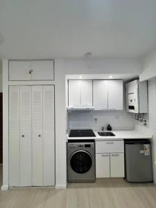 a kitchen with white cabinets and a washing machine at Premium Apartment in City heart in Buenos Aires