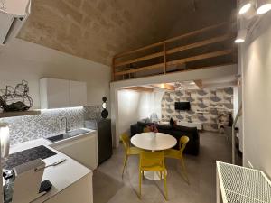 a kitchen and living room with a table and yellow chairs at La casetta di Sofia in Altamura