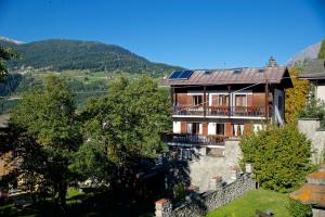 a house with a balcony and mountains in the background at Appartamento Reit in Bormio
