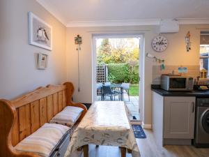 a living room with a table and a kitchen at Little Wash Cottage in Hunstanton