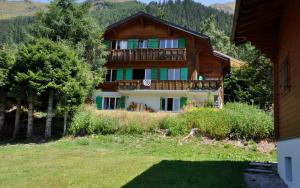 ヴェルビエにあるChalet Christinaの木々が植わる大きな木造の家 +11枚の写真