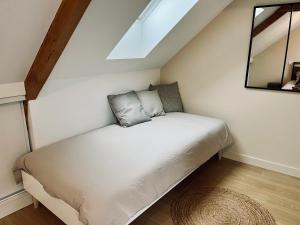 a bed in a small room with a window at Jolie maison et terrasse Ancenis in Ancenis